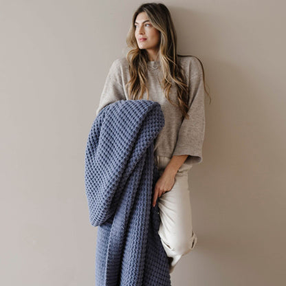 Woman holding Saranoni Waffle Knit XL Throw Blanket - Oxford against a plain background