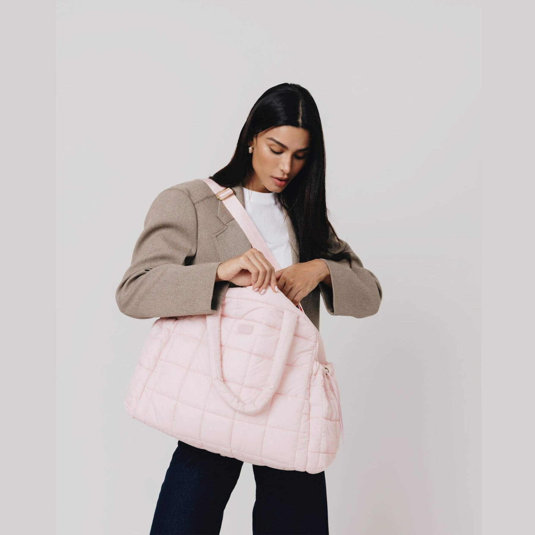 Woman holding augustnoa the weekender duffle bag pink