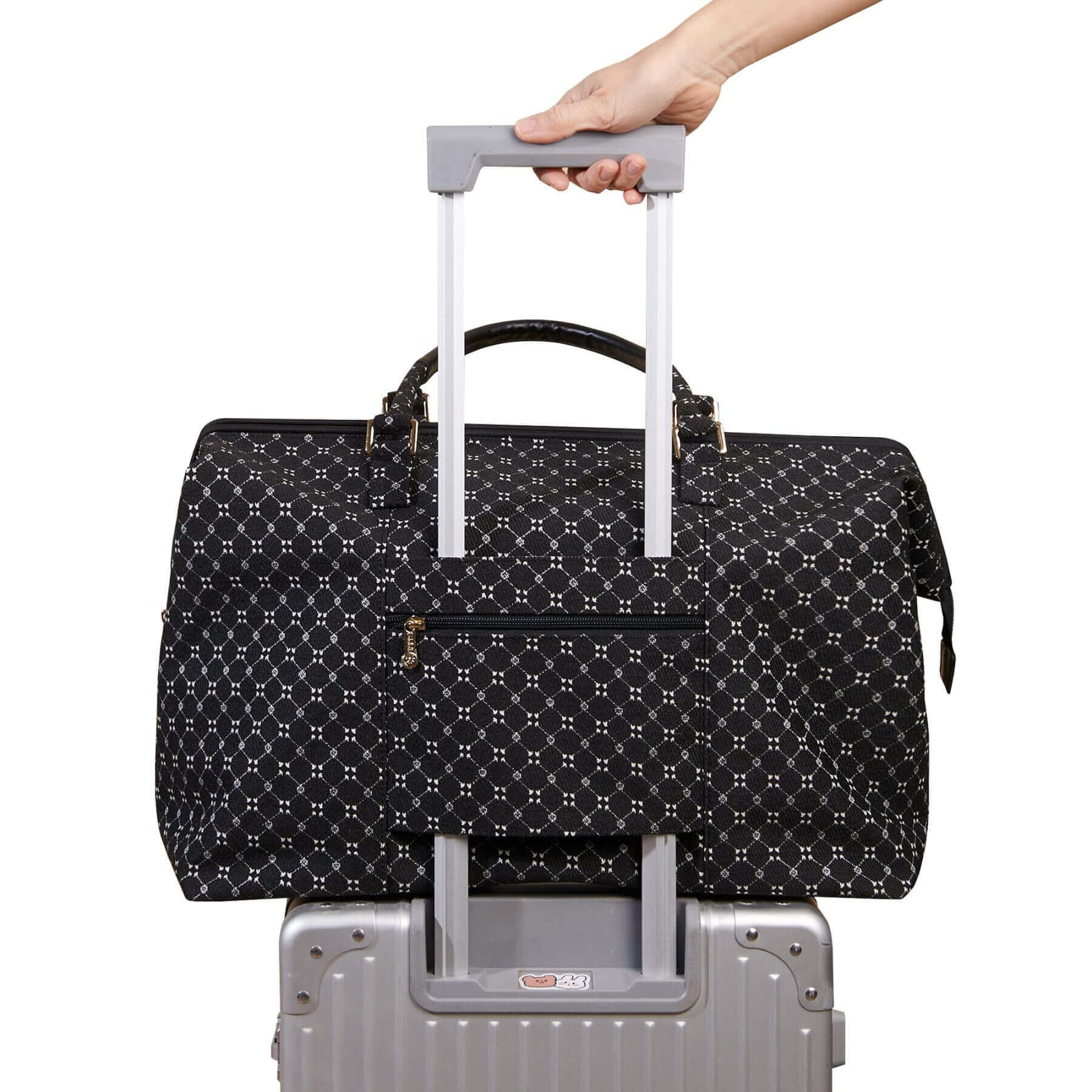 Sunveno Weekender Mommy Bag Travel Duffle - Black on luggage with a hand holding onto its handle