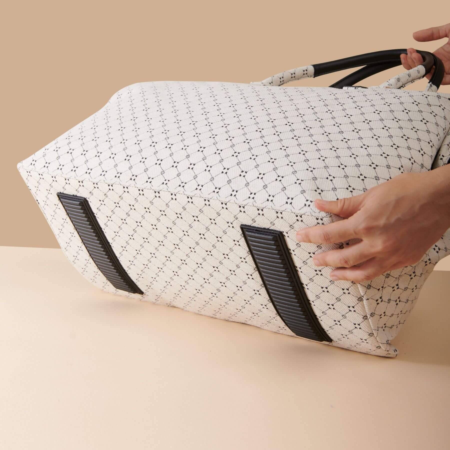 Sunveno Weekender Mommy Bag Travel Duffle - White Classic with black accents held by a hand on a beige background