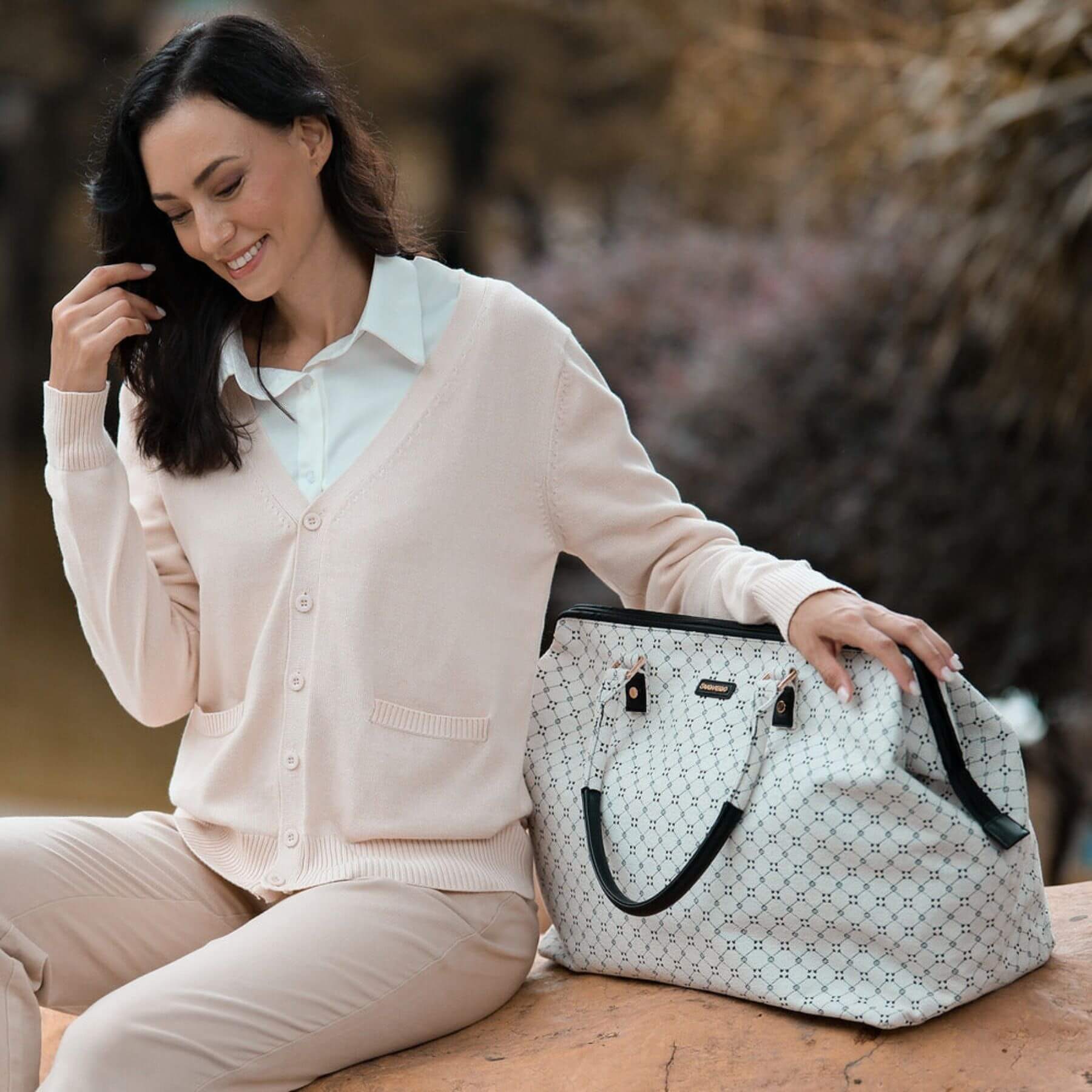 Woman sitting outdoors with Sunveno Weekender Mommy Bag Travel Duffle - White Classic