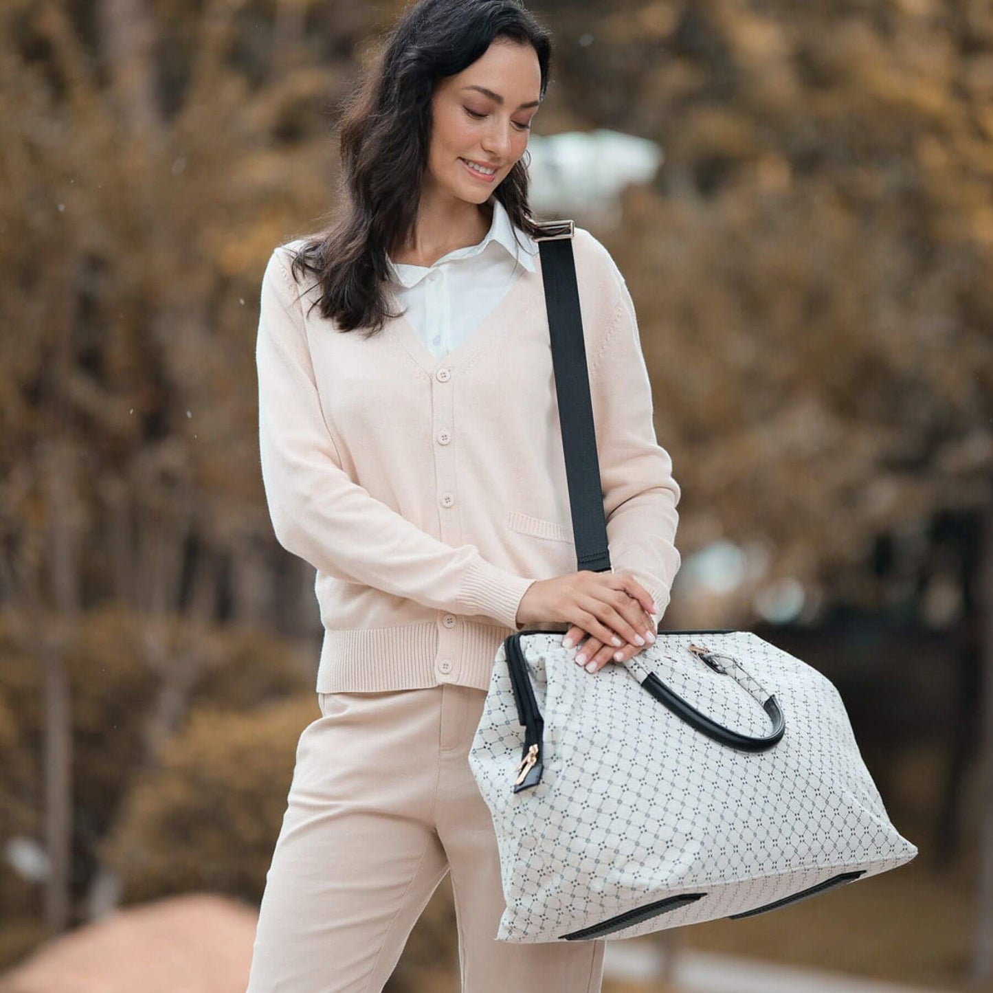 Woman holding Sunveno Weekender Mommy Bag Travel Duffle - White Classic outdoors with blurred natural background