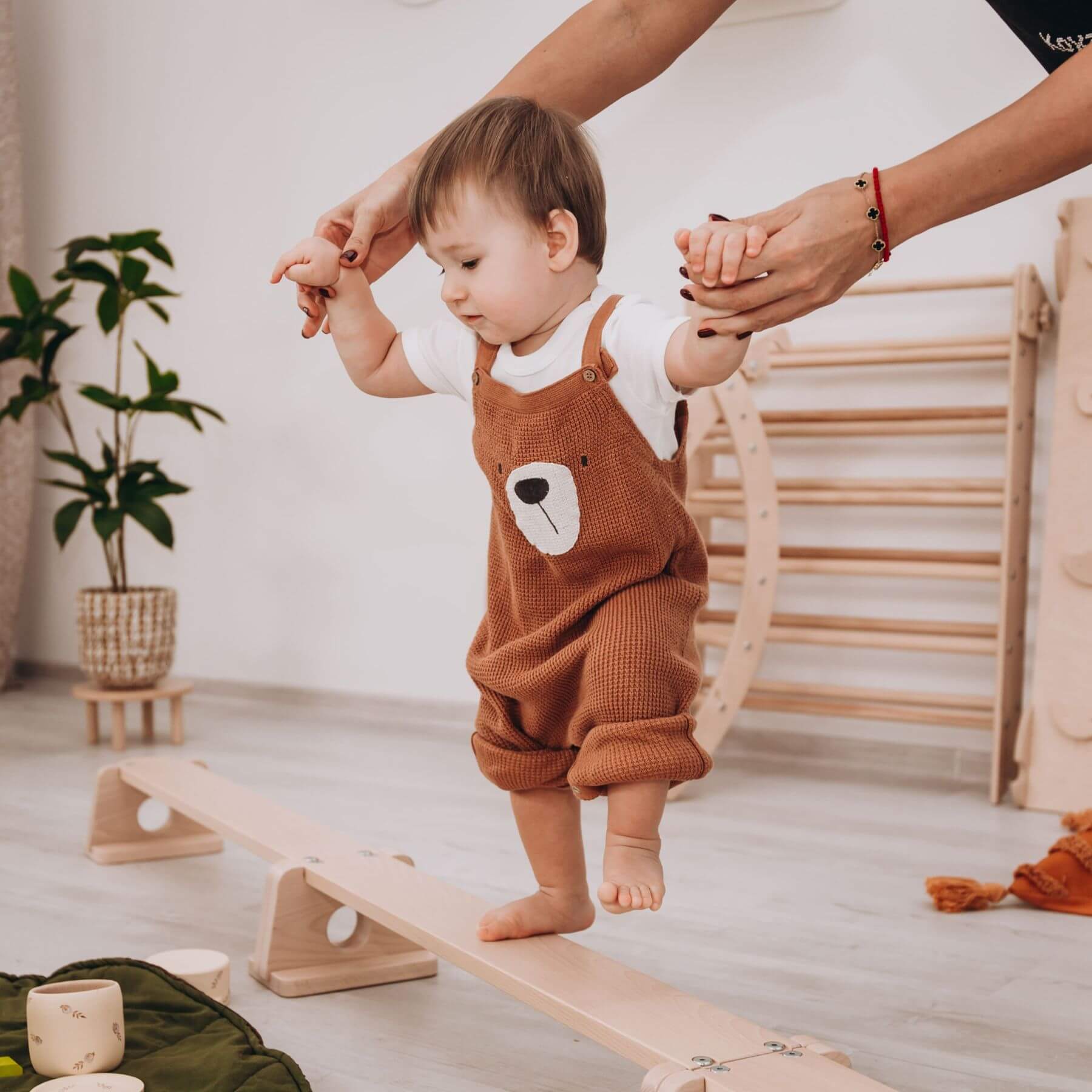 Parent Holding Boy Walking on Wood and Hearts Balance Beam Straight