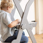 Boy Sitting at Wood and Hearts Foldable Kitchen Tower in Gray