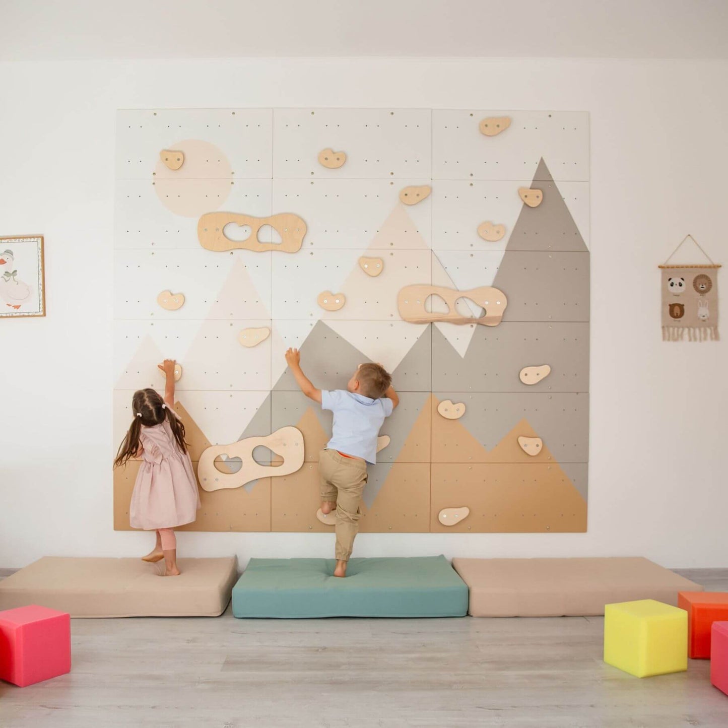 Children playing on Wood and Hearts Indoor Climbing Wall in a room with colorful blocks on the floor.