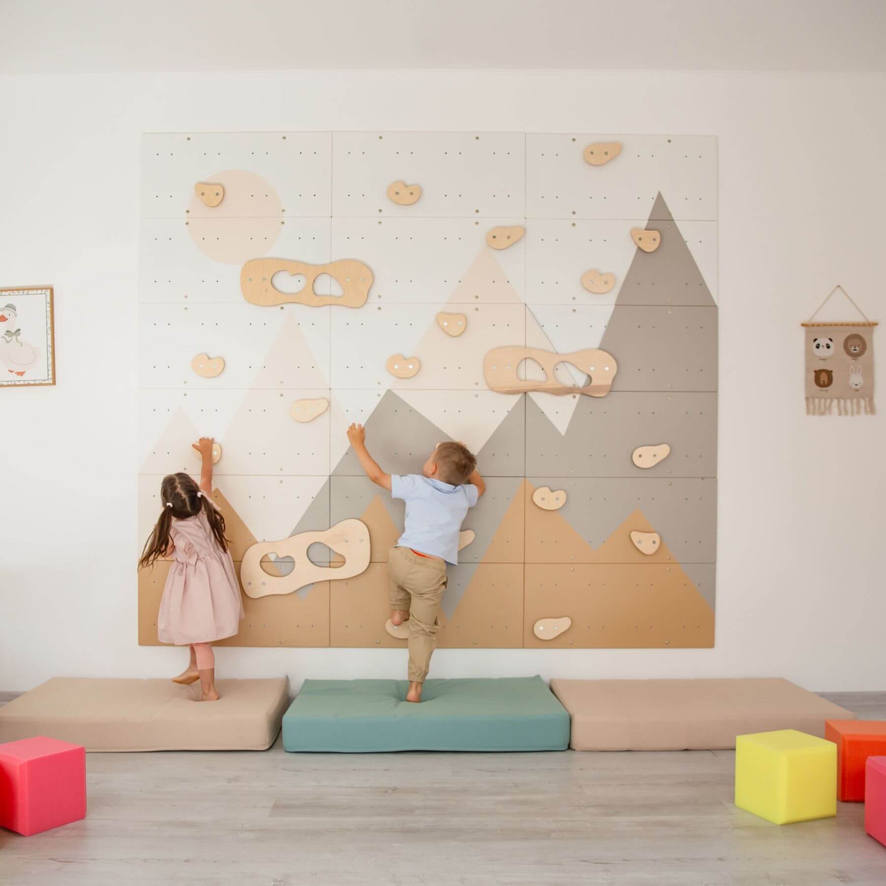 Children playing on Wood and Hearts Indoor Climbing Wall in a room with colorful blocks on the floor.
