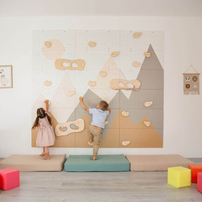 Children playing on Wood and Hearts Indoor Climbing Wall in a room with colorful blocks on the floor.