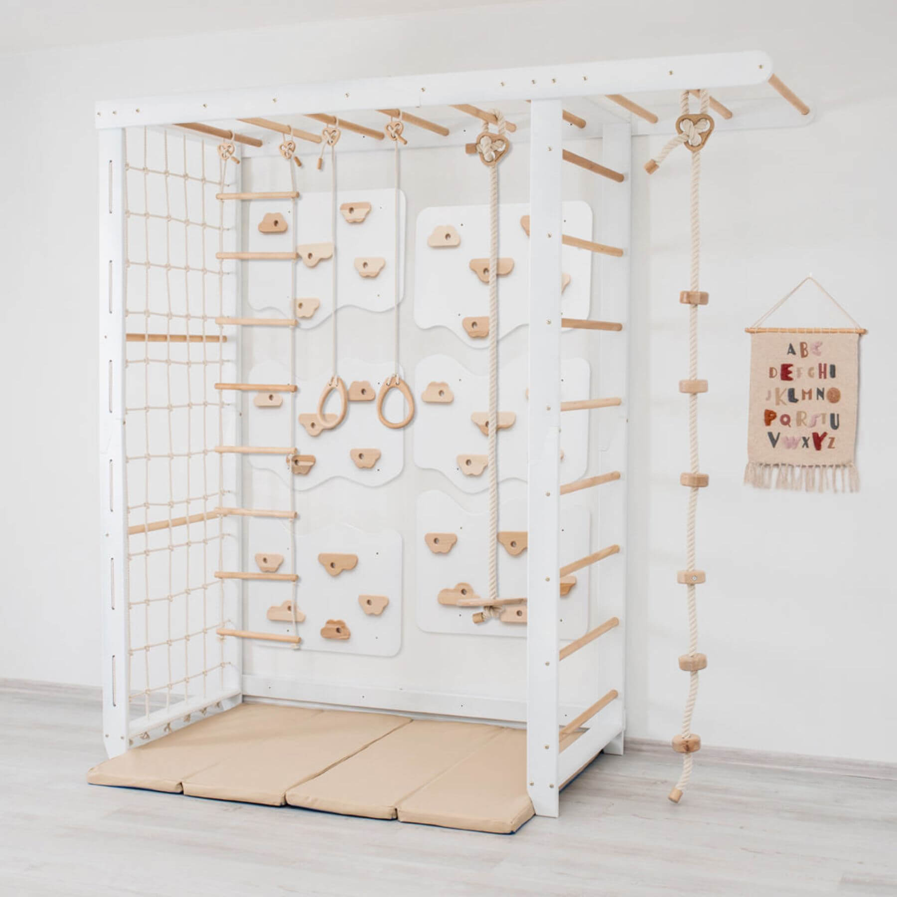 Wood and Hearts Indoor Monkey Bars - White and a soft landing mat on a light wooden floor.