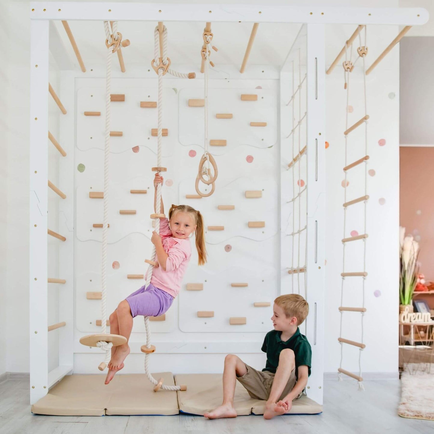 Two children playing on Wood and Hearts Indoor Monkey Bars - White indoors.