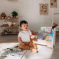 Boy Sitting next to Wood and Hearts Kids Bookshelf in White & Natural Wood