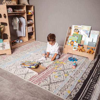 Boy Playing Next to Wood and Hearts Montessori Bookshelf Natural