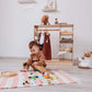 Boy Playing in front of Wood and Hearts Montessori Closet