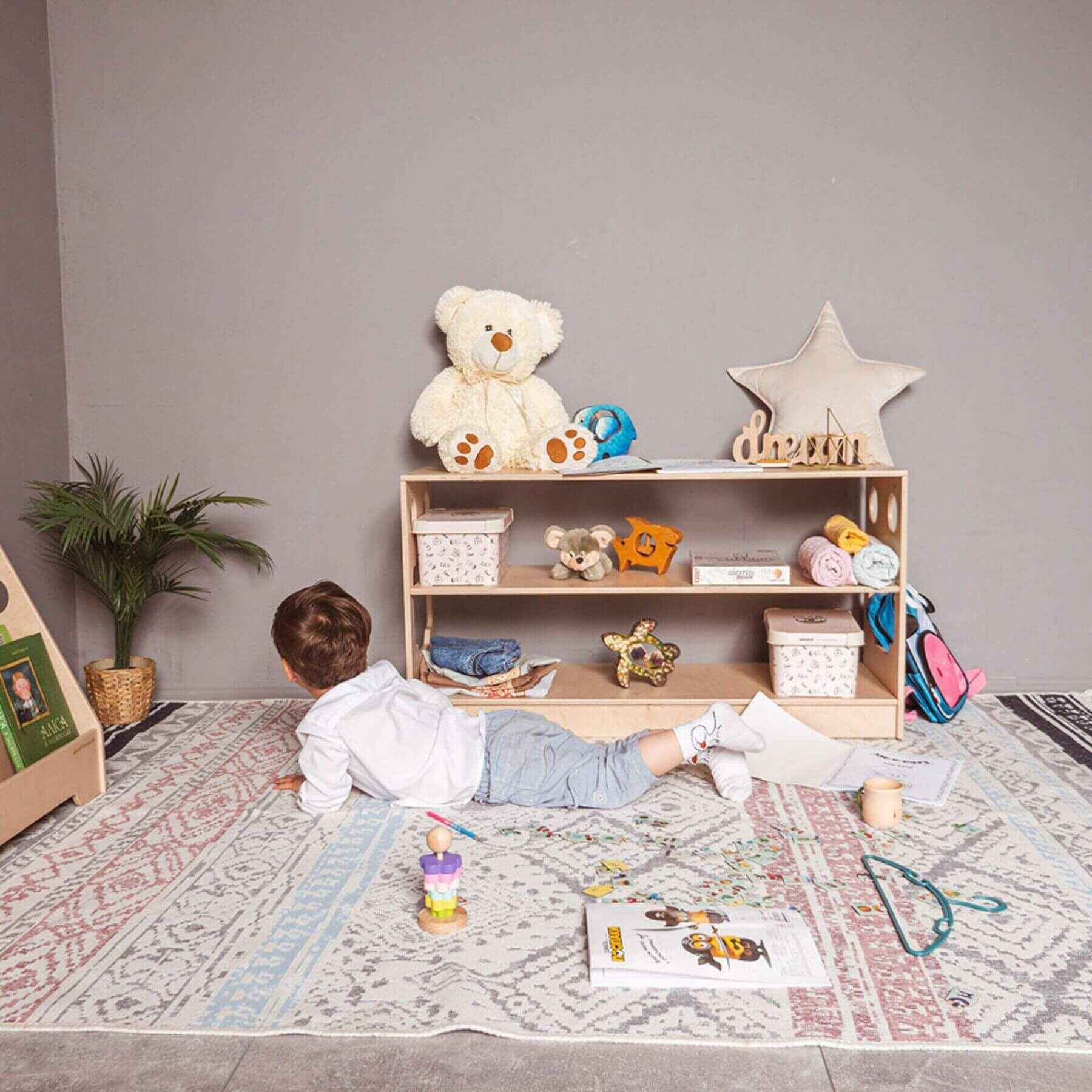 Boy Lying next to Wood and Hearts Montessori Shelf
