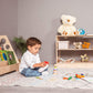 Boy Sitting next to Wood and Hearts Montessori Shelf