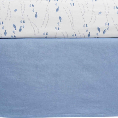 Close-up of a quilt with blue fish pattern on a white background