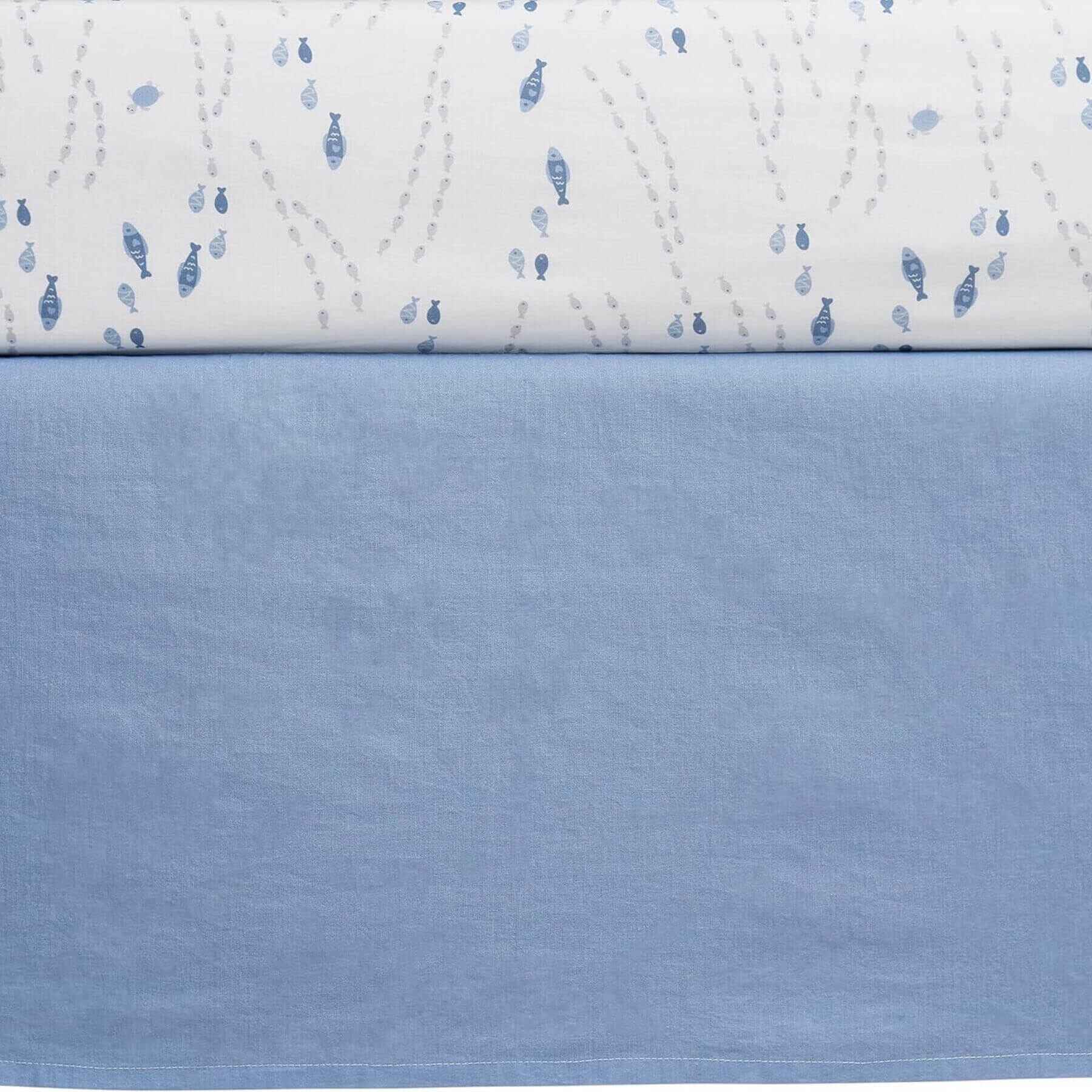 Close-up of a quilt with blue fish pattern on a white background