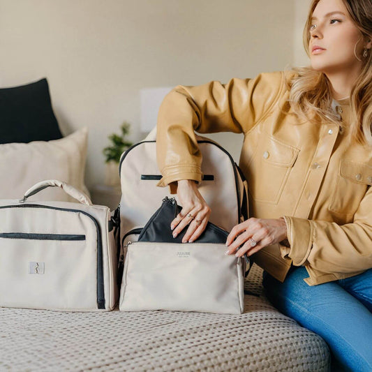 Woman Putting Small Black Bag into Bigger White Witney Carson Pouch