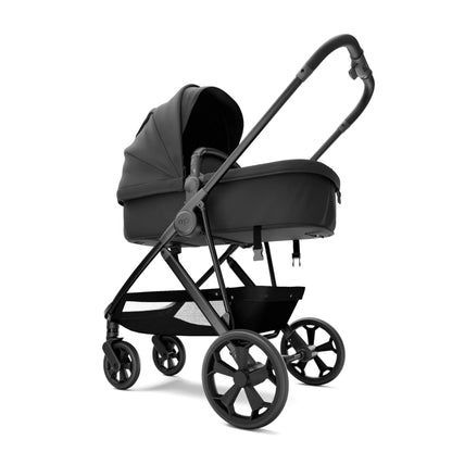 A sleek, modern baby stroller in a monochrome dark gray and black color scheme, shown from a three-quarters side view against a solid white background.