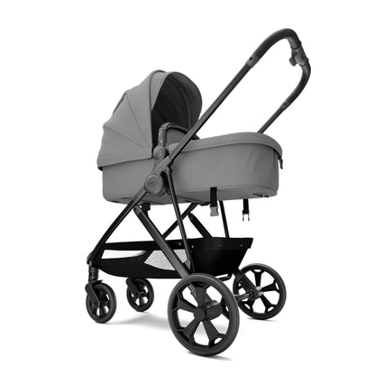 A stroller in a light gray fabric with a black frame and wheels, shown from a three-quarters angle on a solid white background.