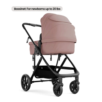 A stroller bassinet attachment in pink fabric mounted on a black stroller frame, shown on a white background with a text label at the top reading 'Bassinet: For newborns up to 20 lbs'.