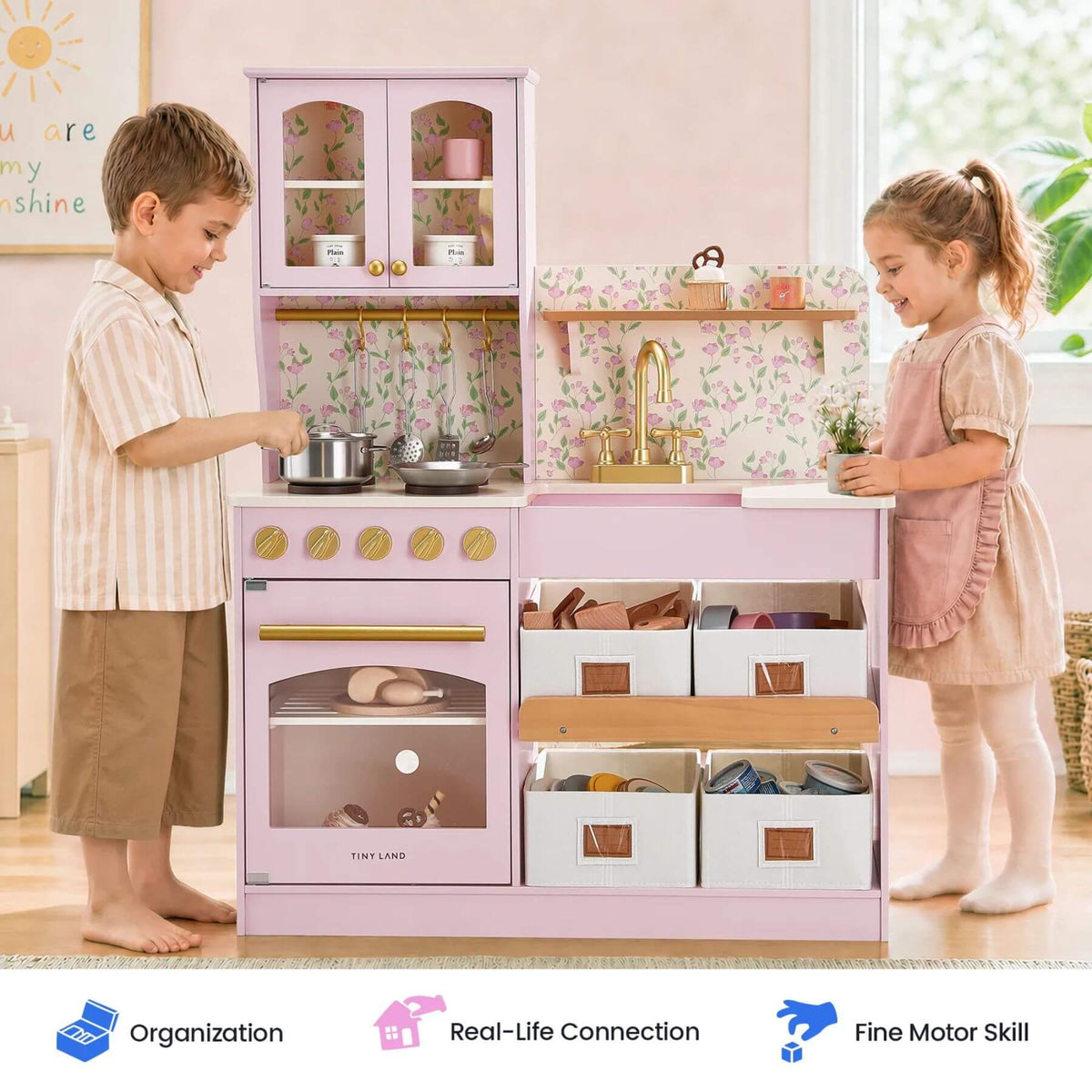 Tiny Land® Wooden Play Kitchen - Pink, shown with two children interacting in a bright room. Three feature badges appear along the bottom.