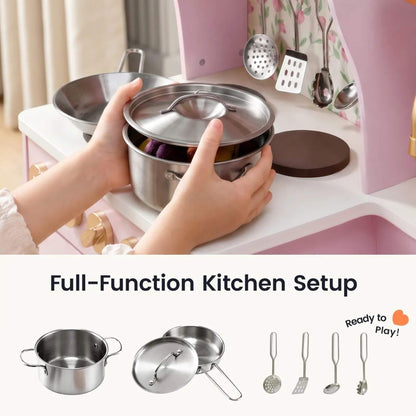A child's hands are shown holding a stainless steel play kitchen pot and lid over a pink toy kitchen counter.