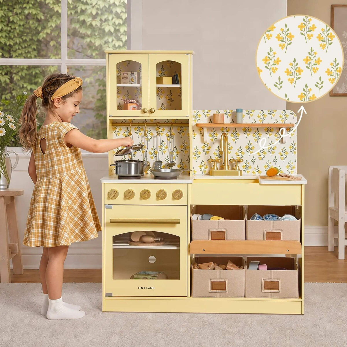 A young girl plays with Tiny Land® Wooden Play Kitchen with Storage - Yellow.