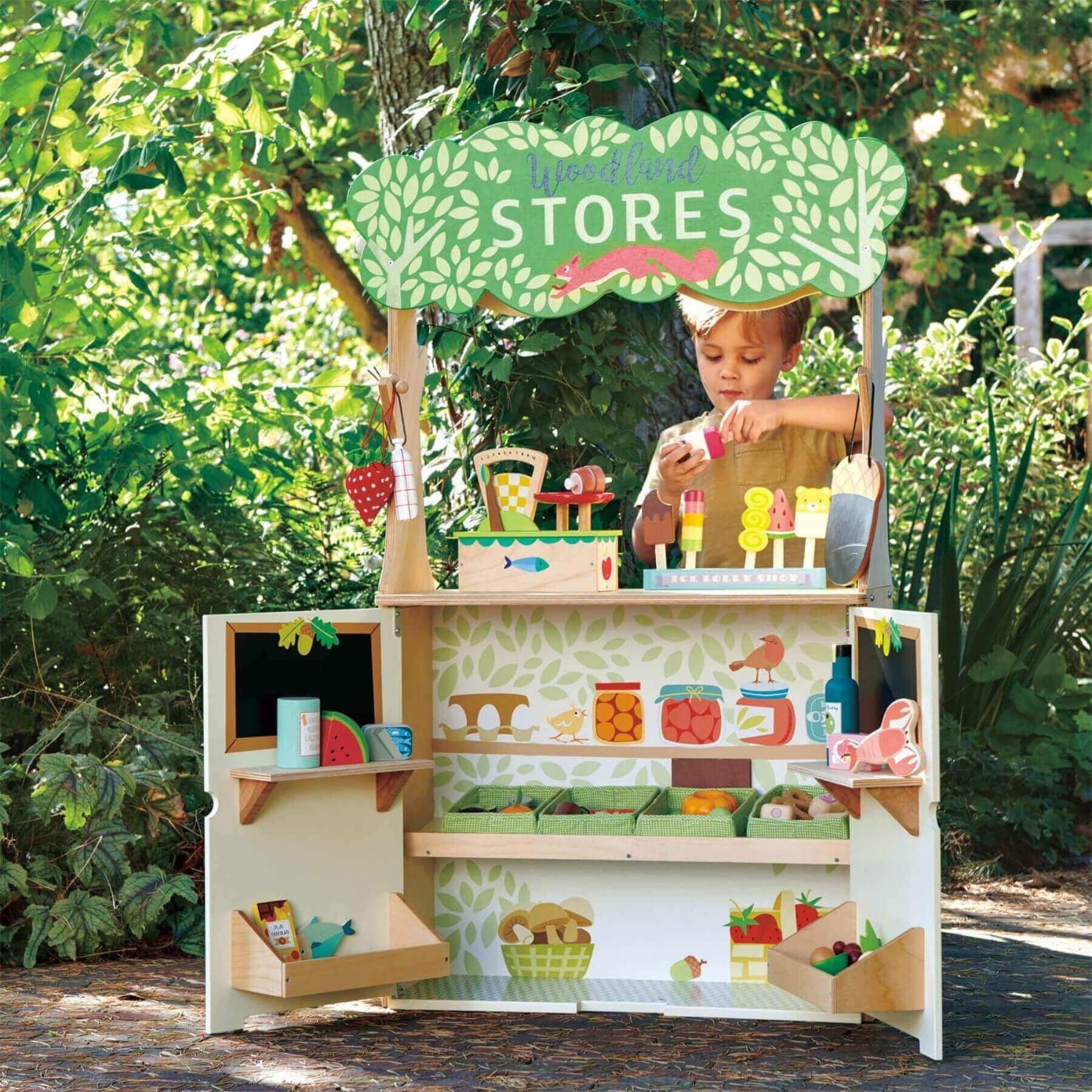 Child playing with Tender Leaf Woodland Stores and Theater outdoors