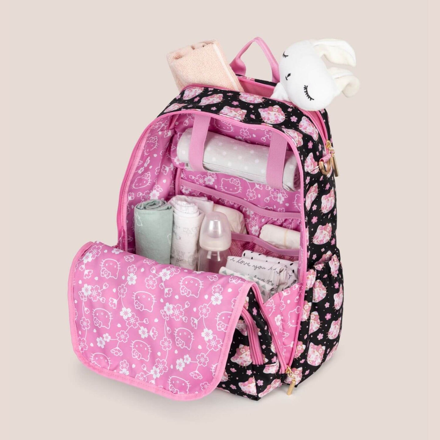 Cherry Blossoms Zealous Backpack with organized contents on a beige background